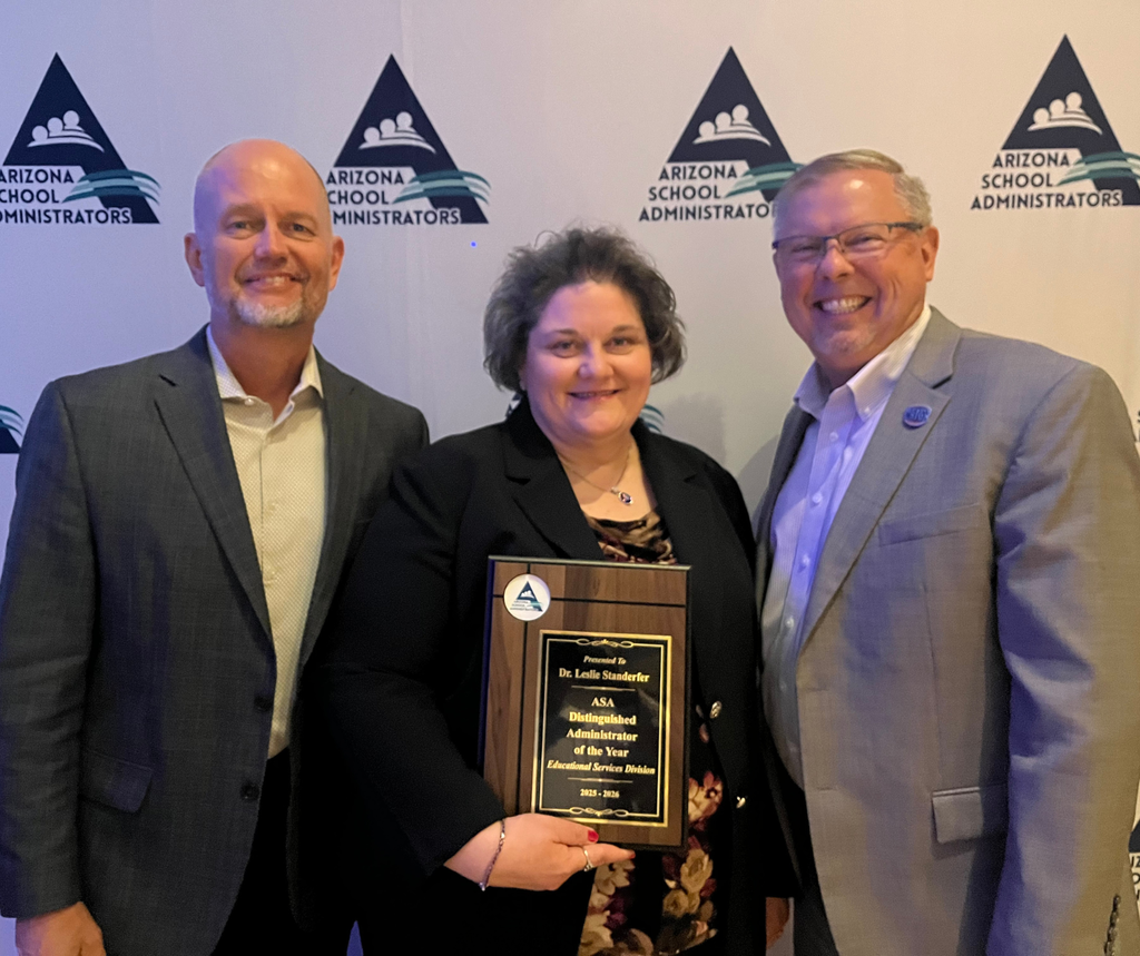 three people posing with an award