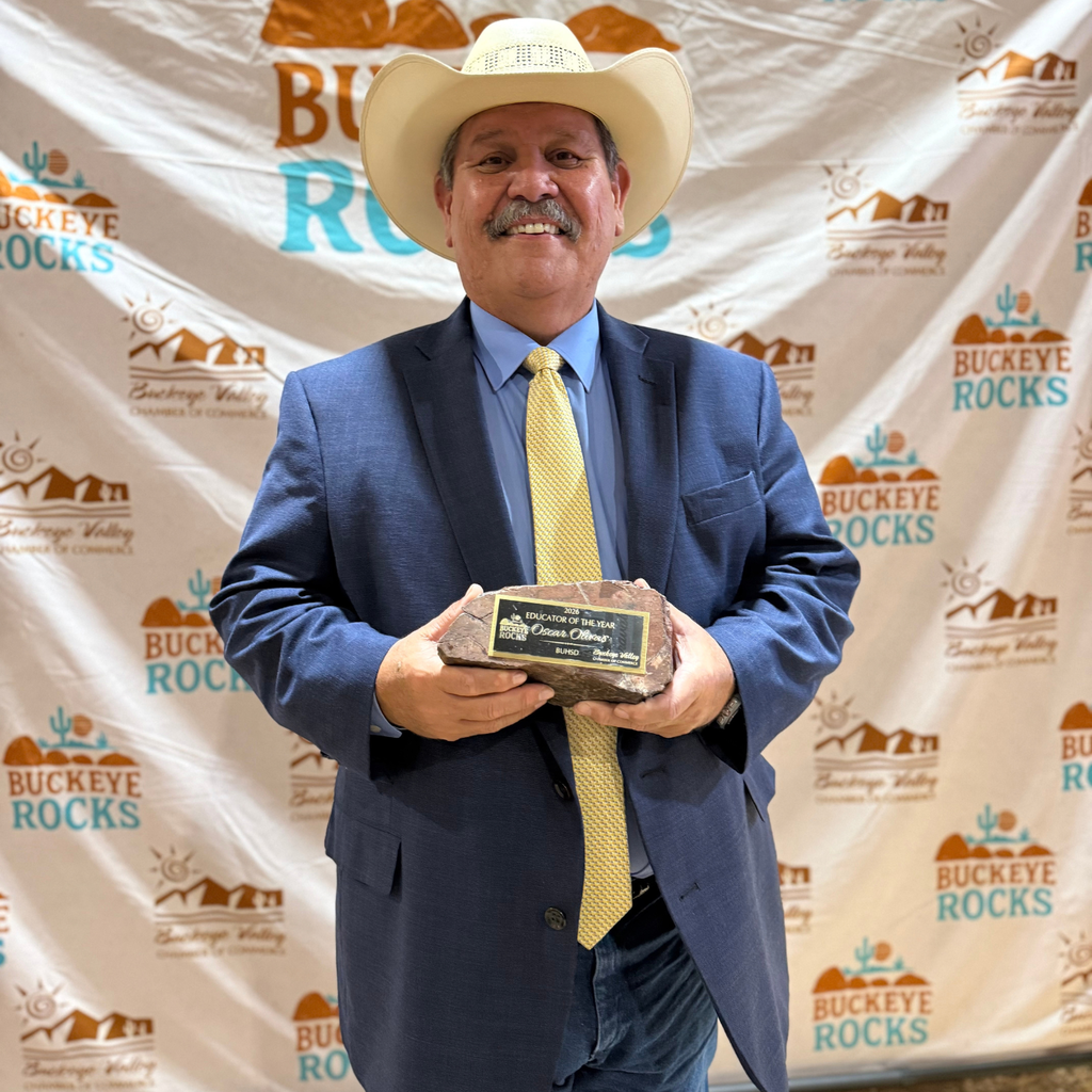 man smiling and holding an award