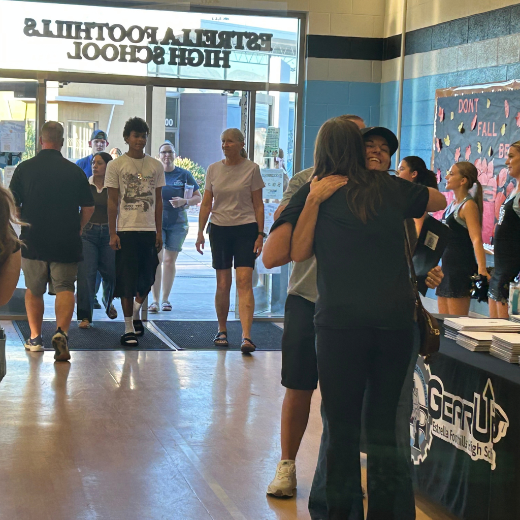A group of people enters a school gym.