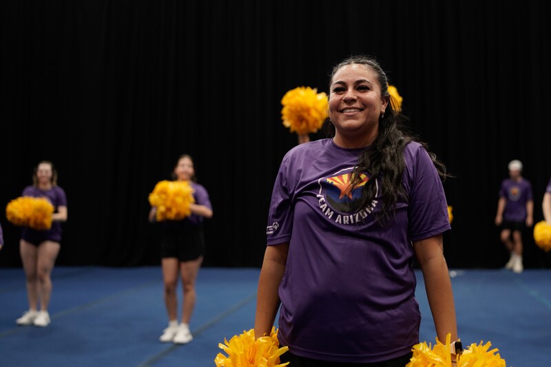 Alexis on the floor cheering with moms