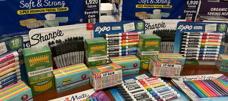 Table filled with classroom supplies.