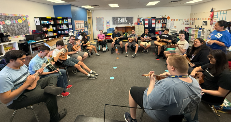 Unified Music practicing ukuleles in a classroom