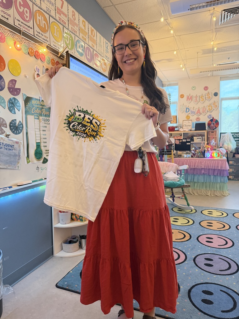 Ms. Edwards holding up one of the color run t-shirts