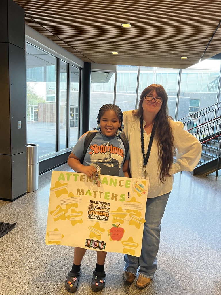 Student and Attedance Clerk pose with an "Attendance Matters" poster