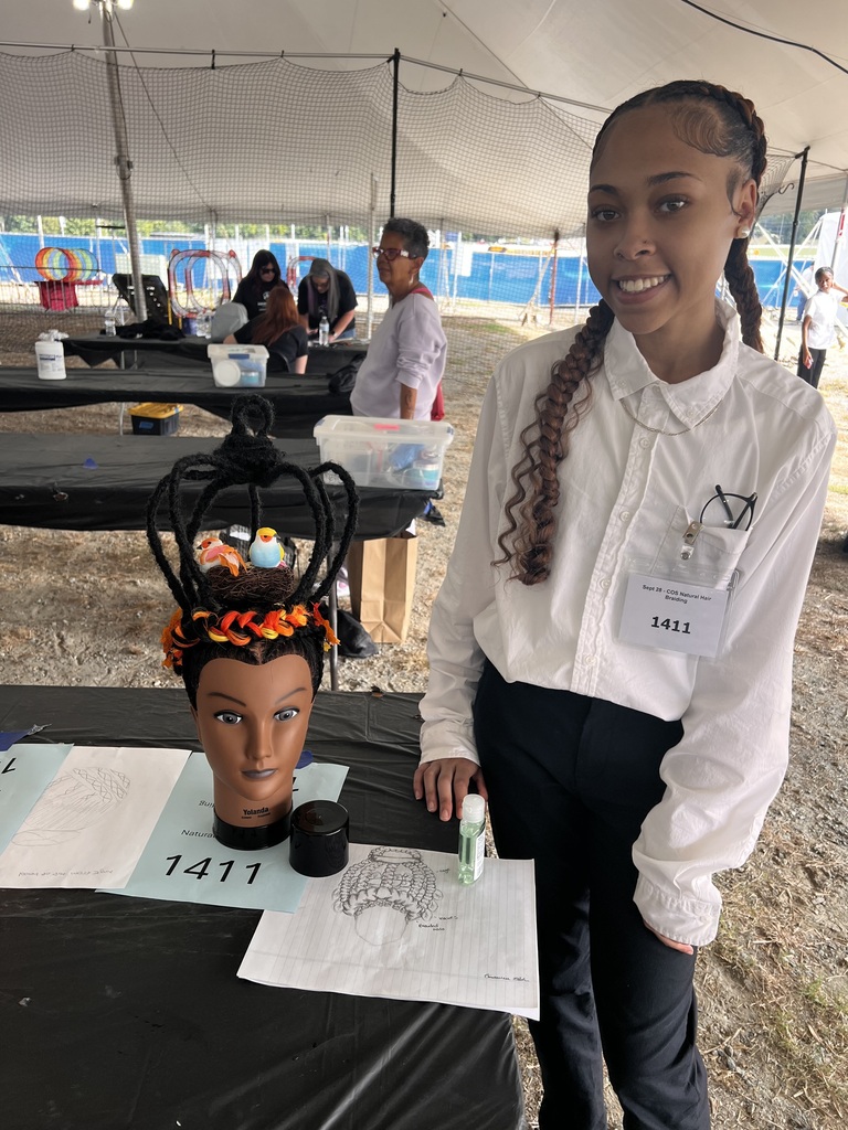 Omauria posing with her entry and design drawing