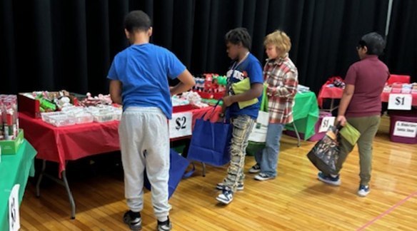 Kids at a table shopping in an auditorium