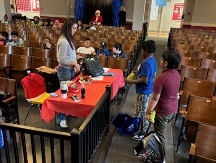 Kids at a table shopping in an auditorium