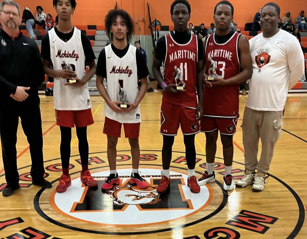 High School basketball players and coaches posing with Trophies