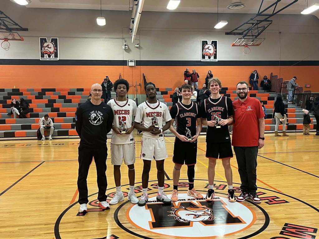 High School basketball players and coaches posing with Trophies