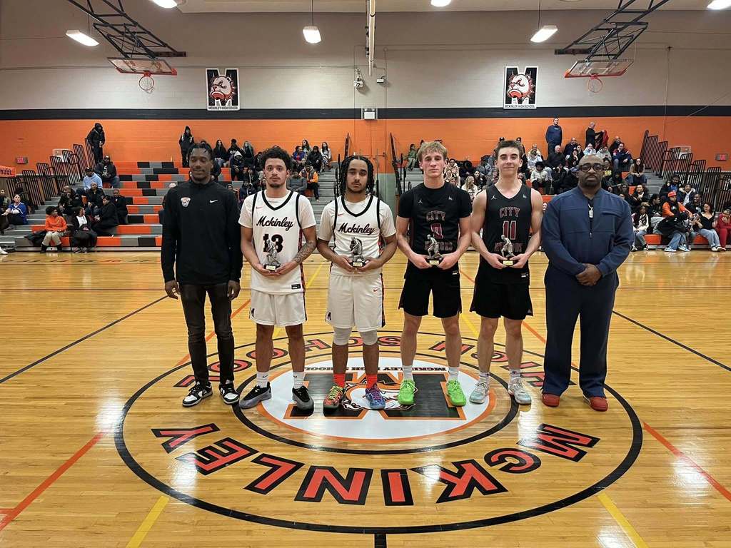 High School basketball players and coaches posing with Trophies