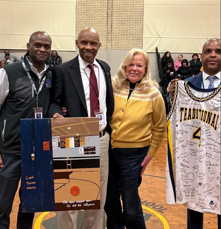 Coach Bryant with Principal, AD and Guy holding a jersey.