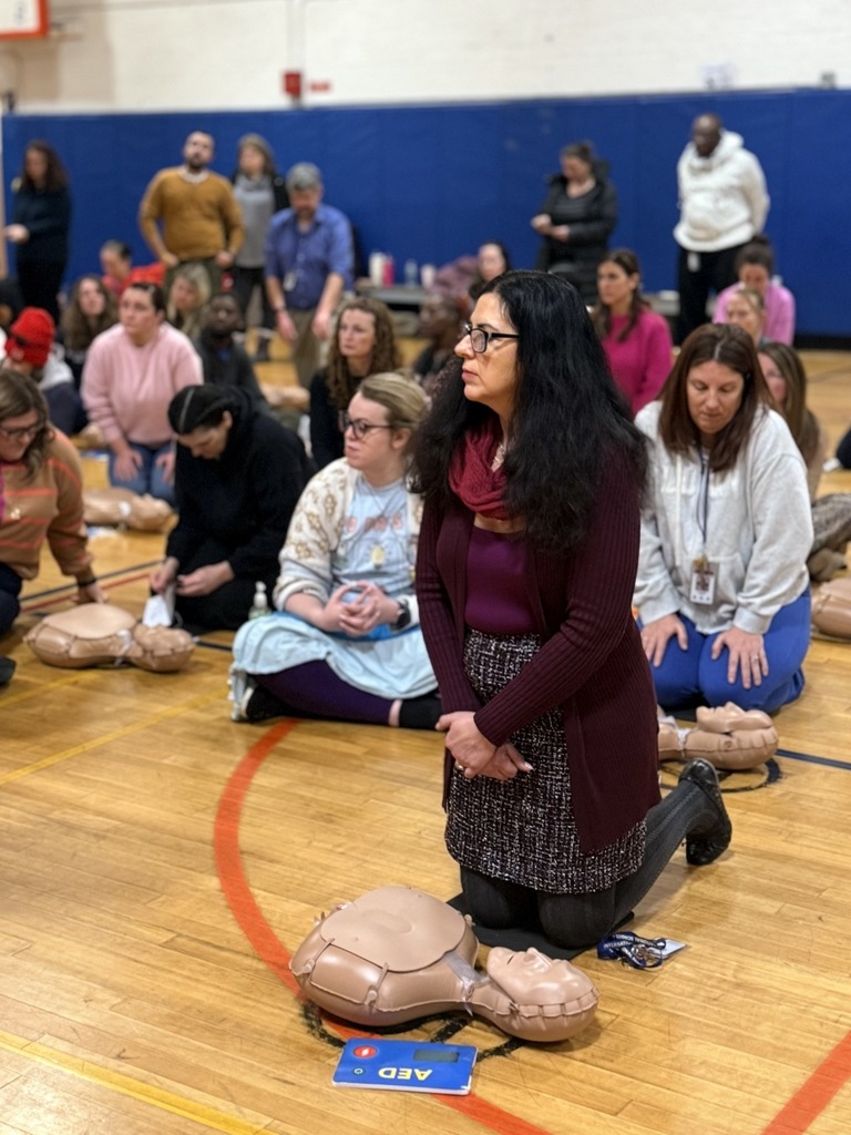 Teacher Learning CPR in a Gym