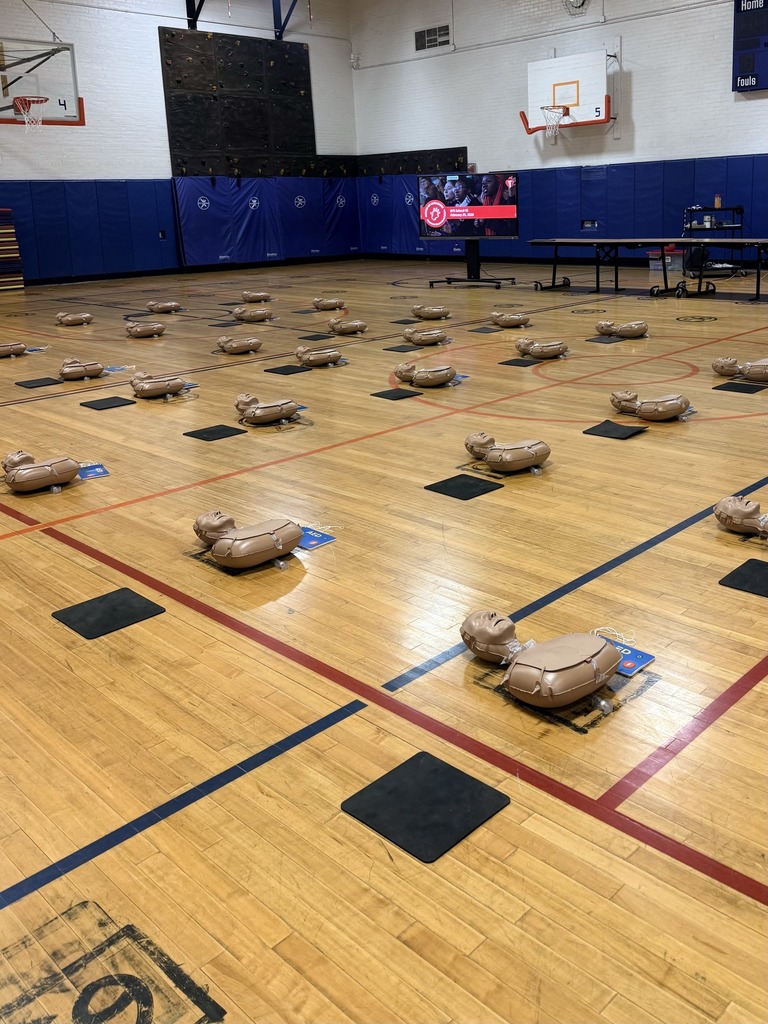 Teacher Learning CPR in a Gym