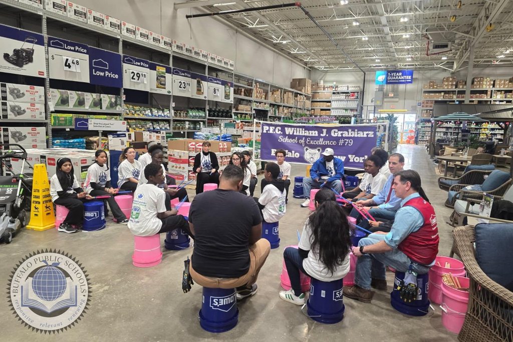 Students in a drum circle playing on buckets at Lowes Department Store