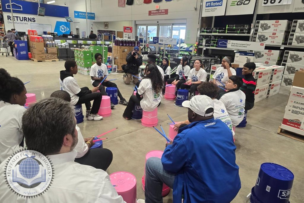 Students in a drum circle playing on buckets at Lowes Department Store