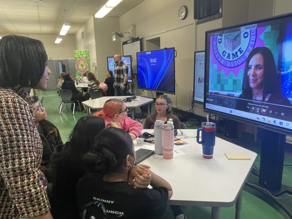 A group of student in front of a  display board editing video as a  group