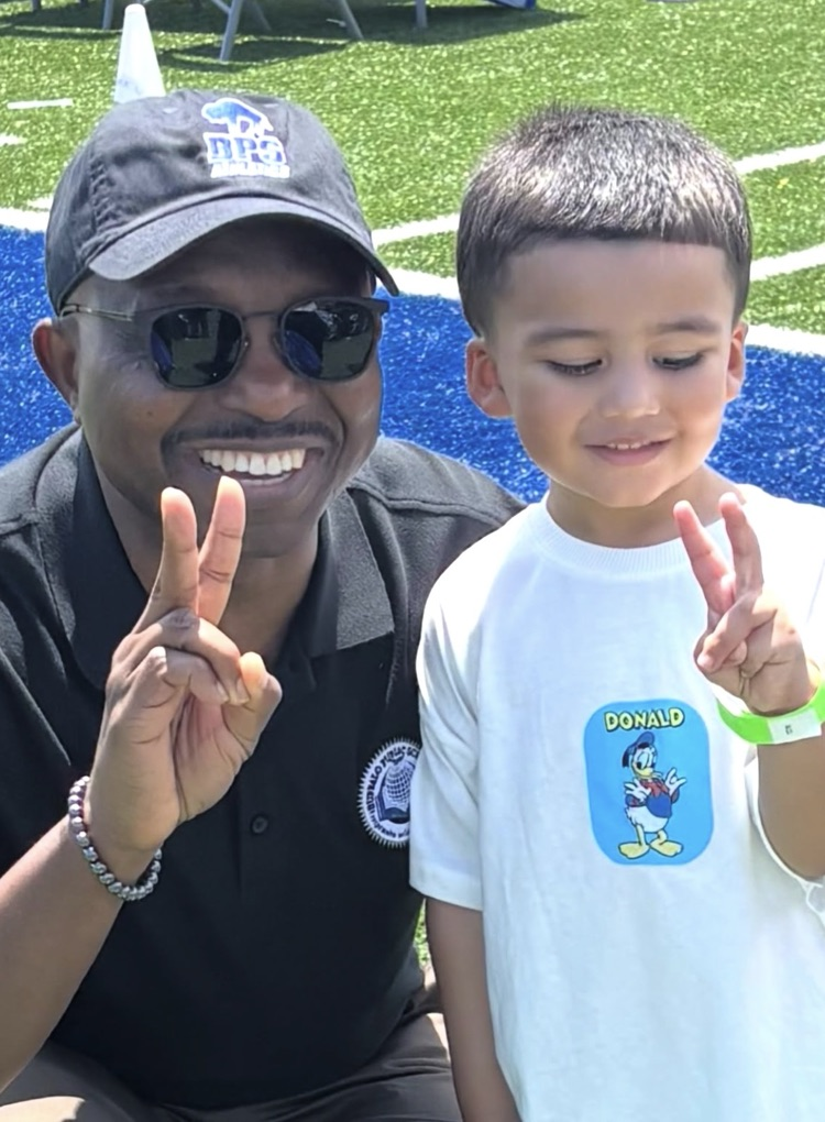 superintendent giving peace sign with student
