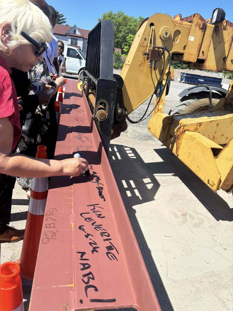 people signing steel beams