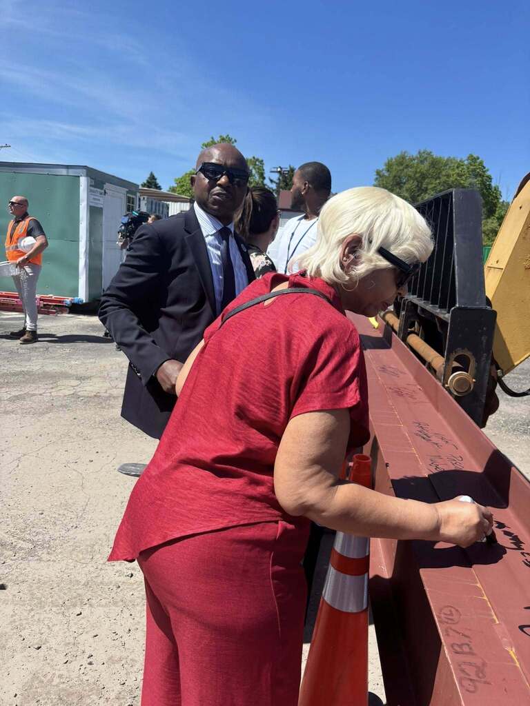 people signing steel beams