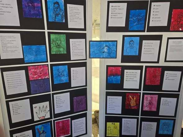 “Panels displaying multiple student artworks arranged in grids, including colorful portraits and hand drawings paired with written reflections.”