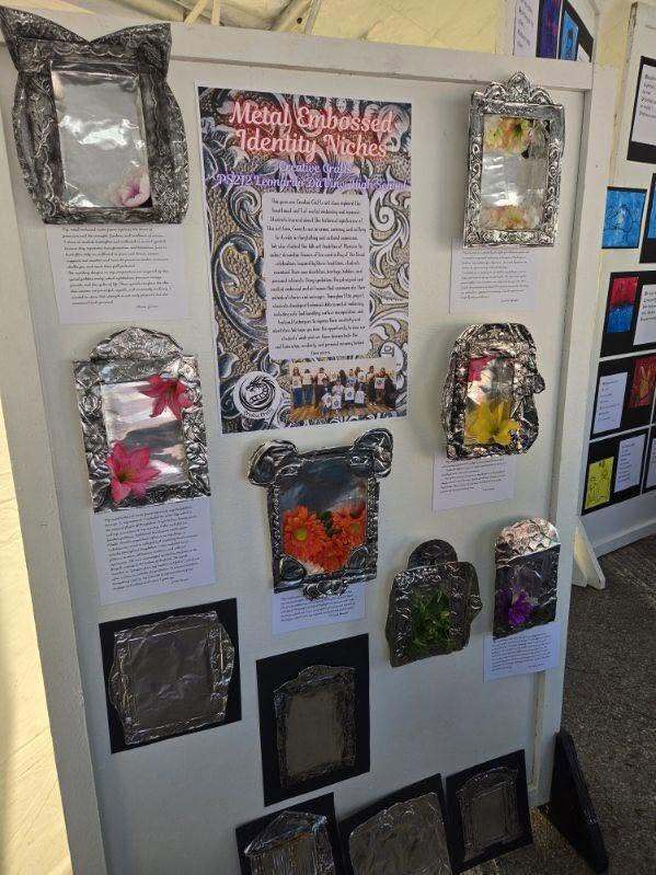 Display board titled ‘Metal Embossed Identity Niches’ featuring multiple student-created embossed metal artworks with decorative frames and written descriptions.
