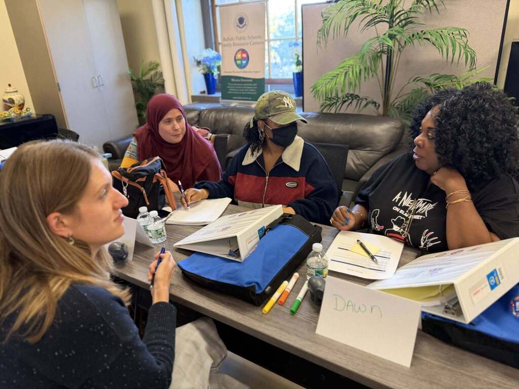 BPS parents conversing, and training in  a classroom