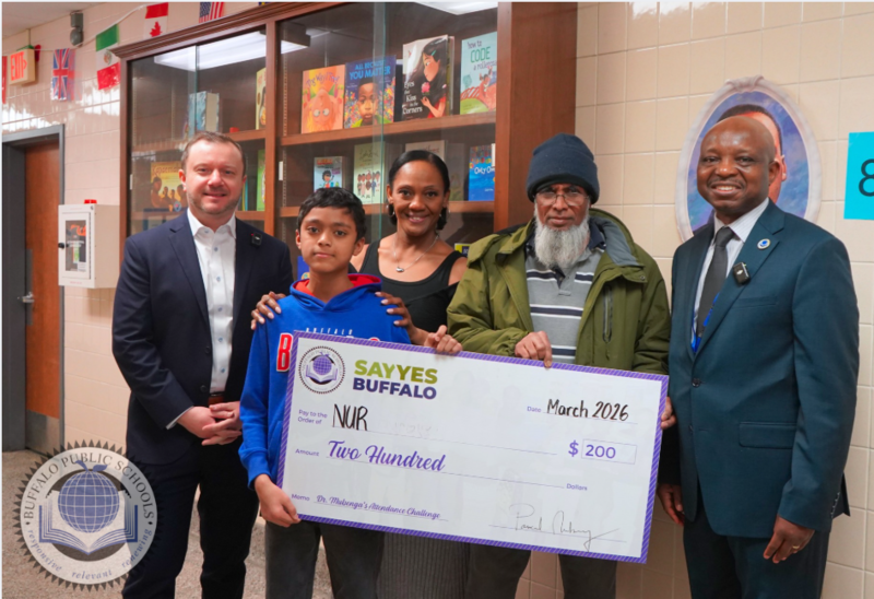 Student holding a large size check with Superintendent and Other BPS Staff 