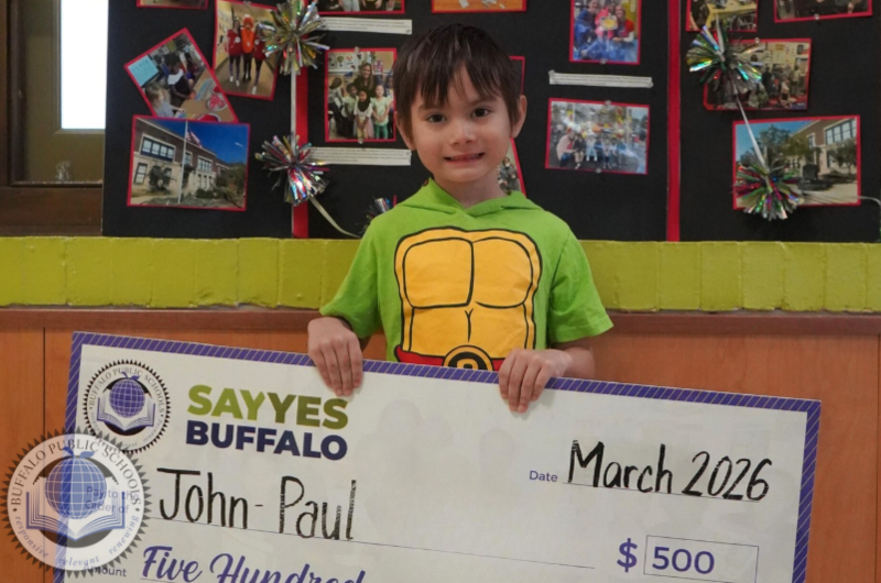 Student holding a large size check 