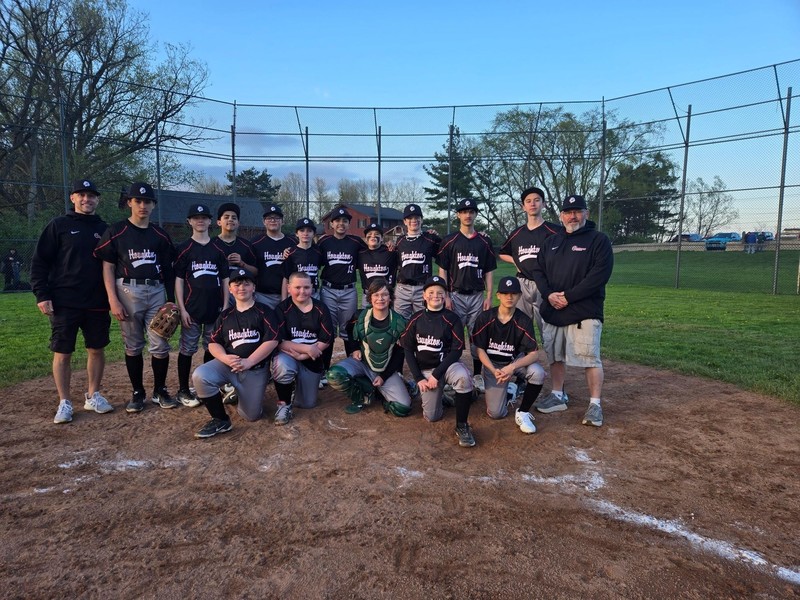 Houghton Lions Baseball team in group photo with coaches at home plate