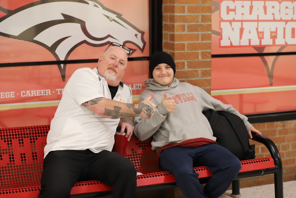 Student and staff member sitting on bench