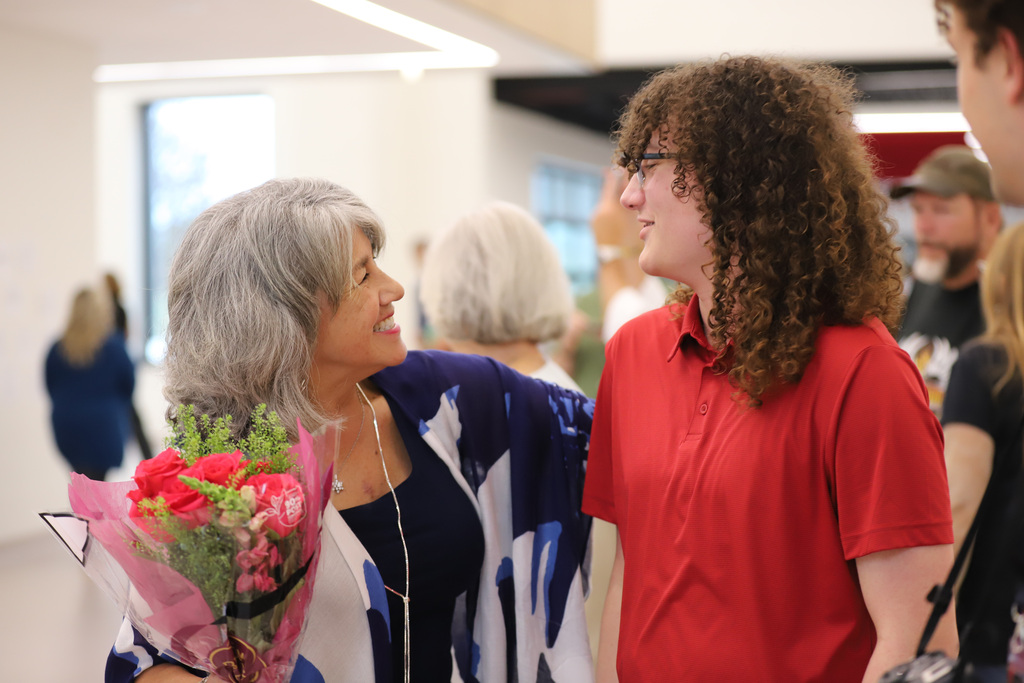 BEHS Arts Showcase from September 24th:  Judy Chandler smiling and talking with a former student