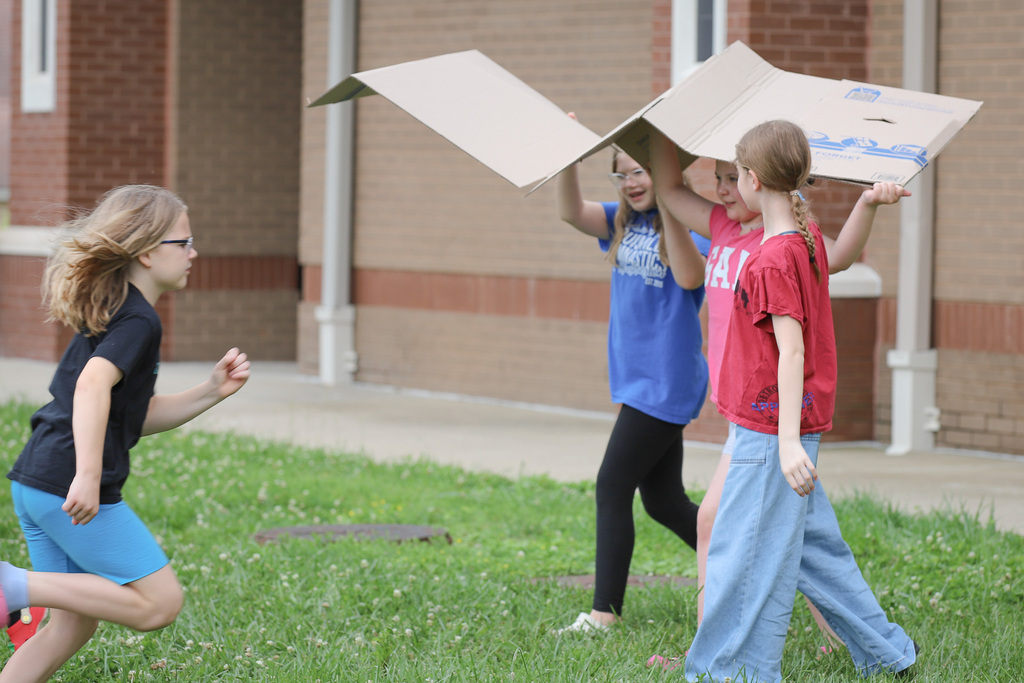 CES Pollinator Garden: students carrying cardboard boxes to use for the pollinator garden
