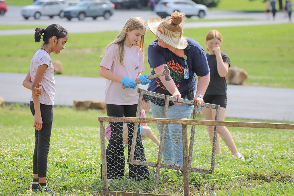 CES Pollinator Garden: hammering the fence into place to build the garden space