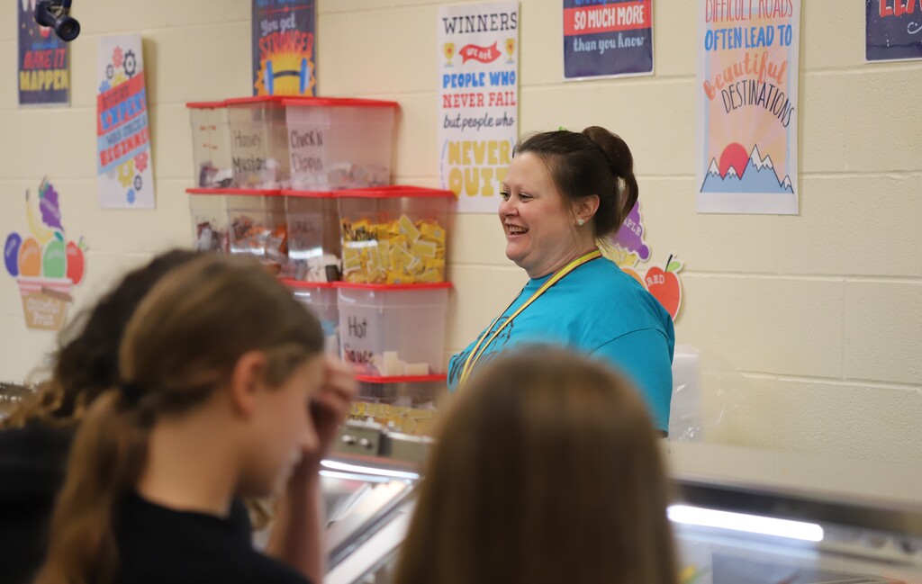 National school lunch week; students smiling and greeting the school nutrition worker