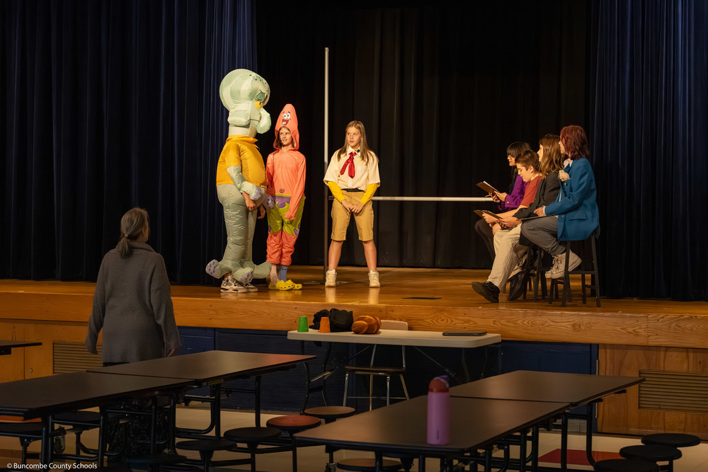 Students perform a Spongebob-related skit on stage during dress rehearsal.