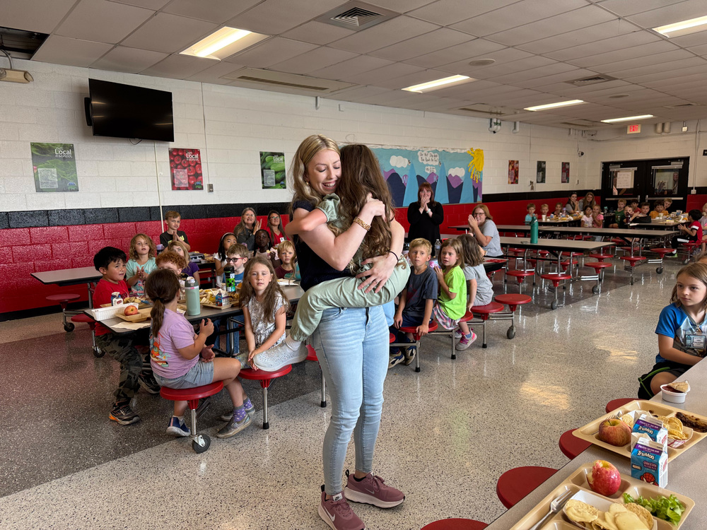 Older sister visiting her younger sister at school during lunch. 