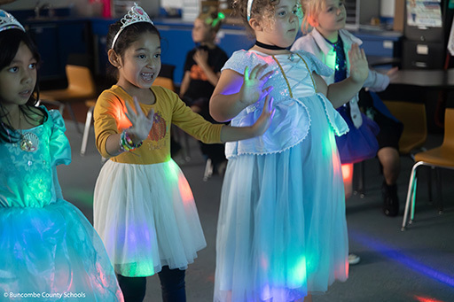 Girls dressed as princesses dancing.