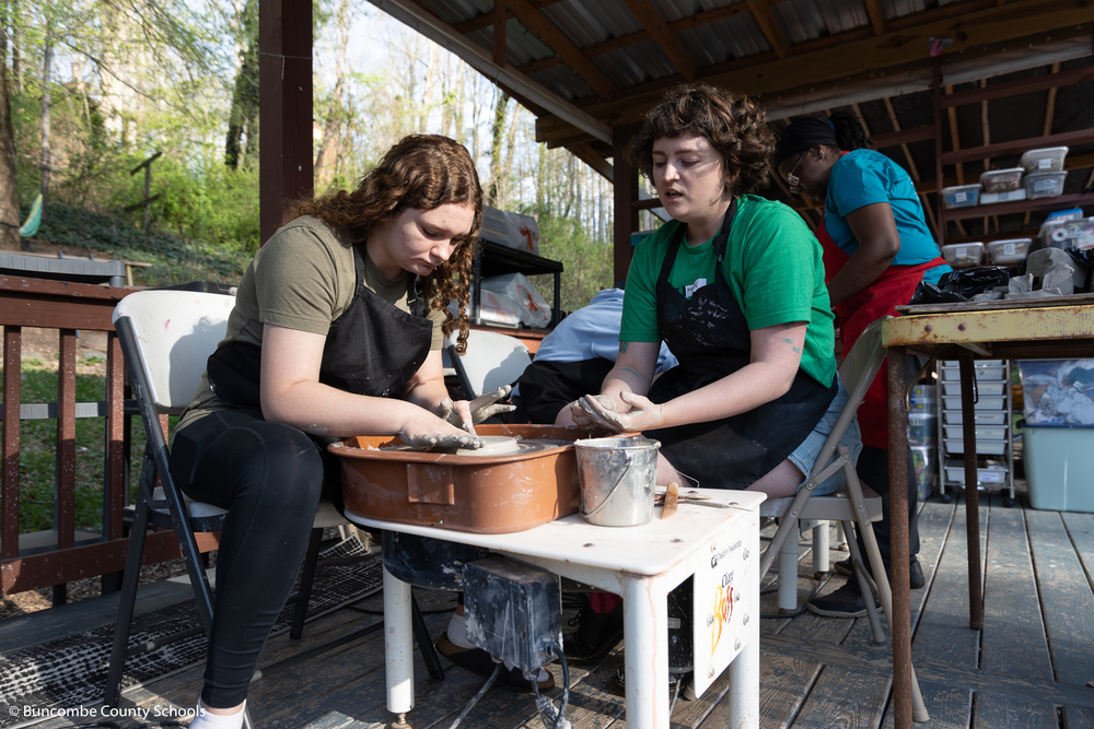 Student making a plate on the pottery wheel. 