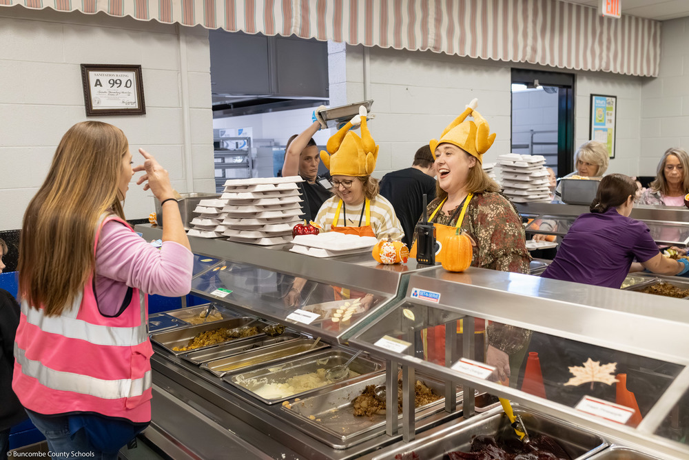 Leicester Elementary assistant principal Cindy Jamison and principal Jamie Slagle work the cafeteria line wearing turkey hats