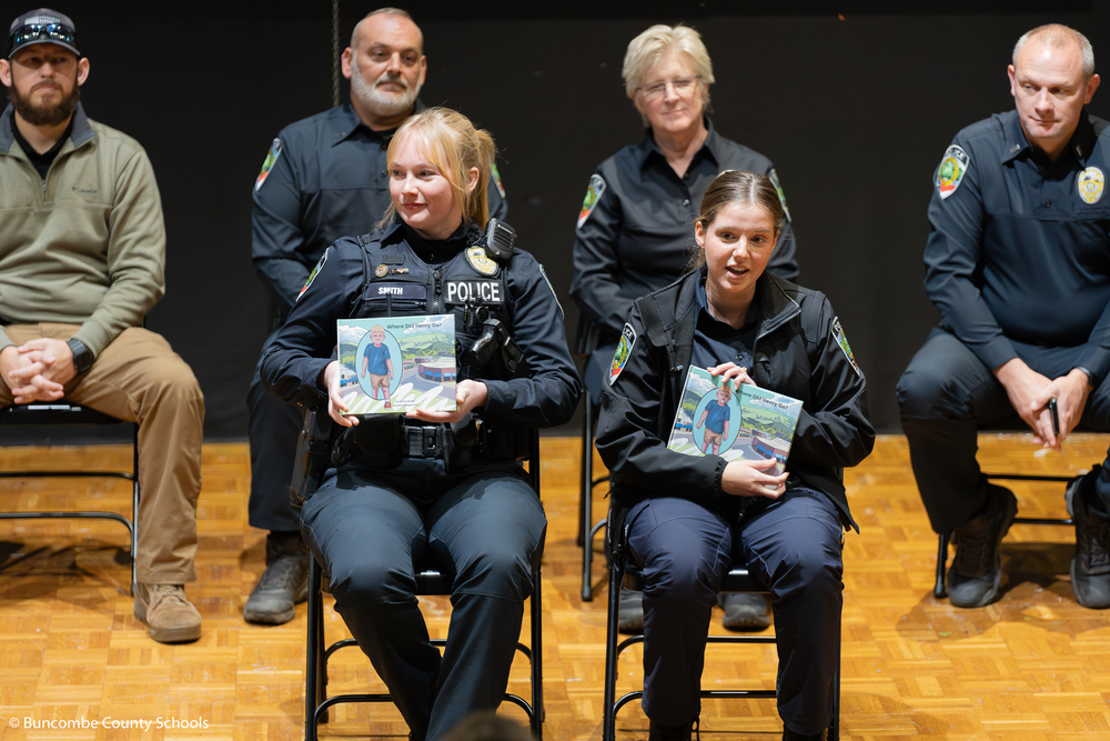 Two female Black Mountain Police officers holding the book "Where Did Henry Go?".  They were getting ready to read the book to the entire school at Black Mountain Primary. The pair wrote the children's book. 