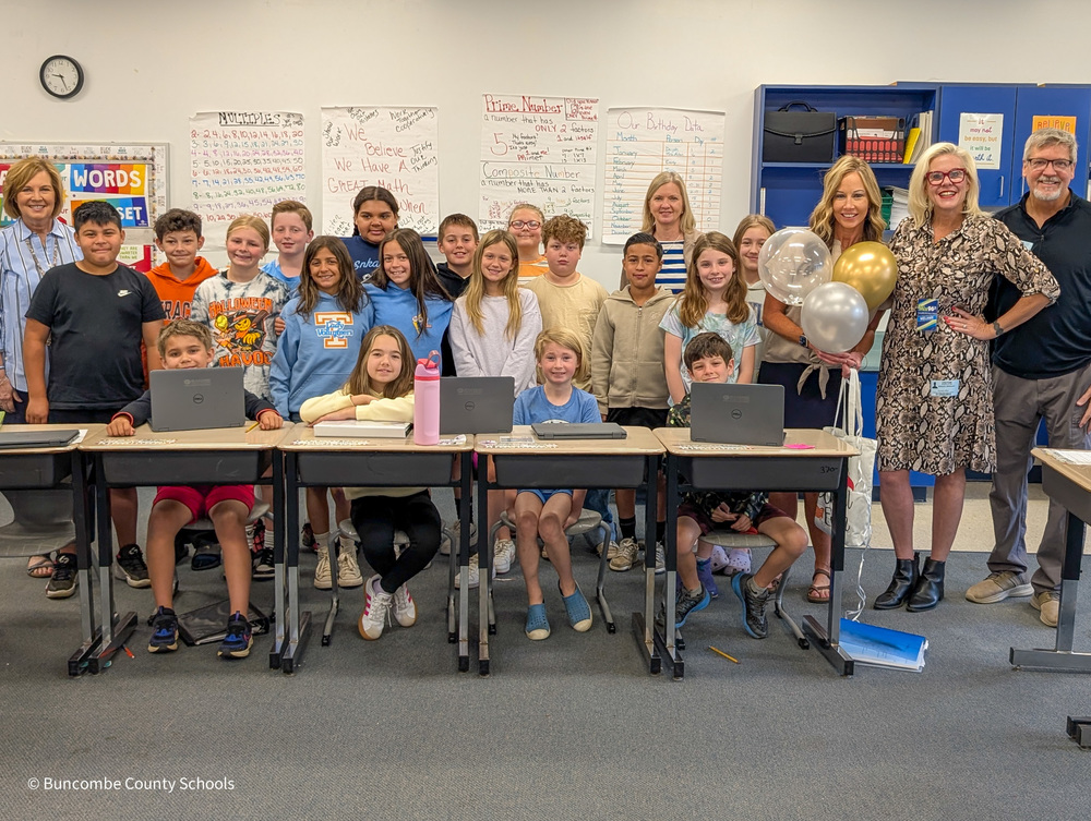 Ms. Atkinson poses for a photo with her students, principals, and Melanie from Mix 96.5