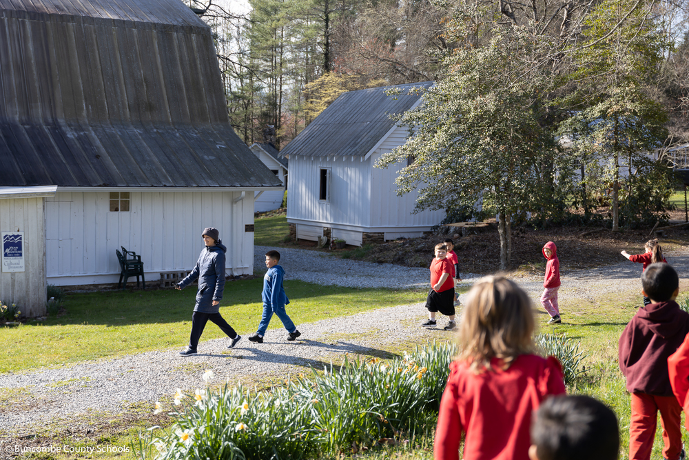 Students are walking around the farm with a tour guide.