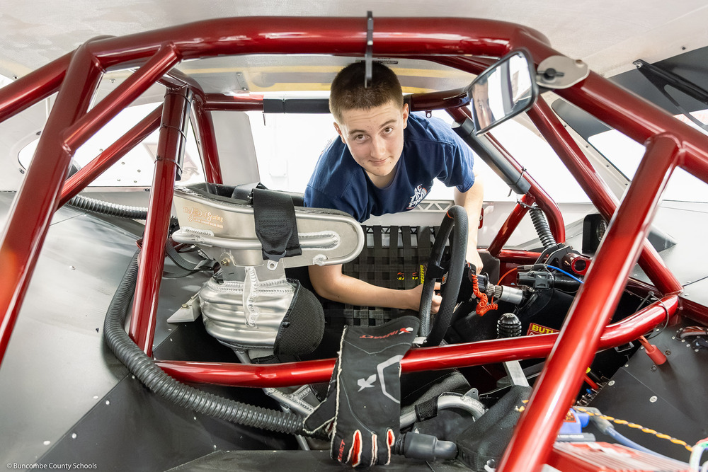 Hudson Canipe leans into his racecar.