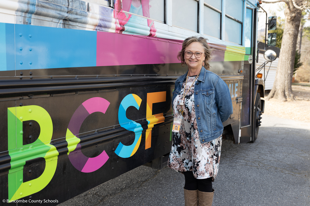 Pricilla Lunsford standing beside the Bookmobile for a photo. 