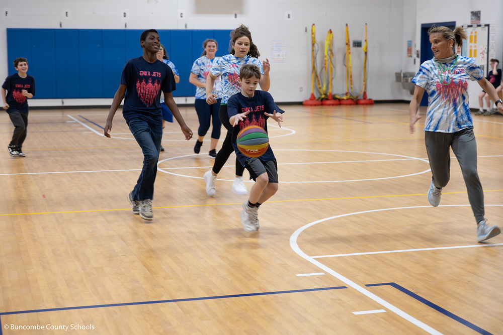 Student dribbling a ball down the court. 