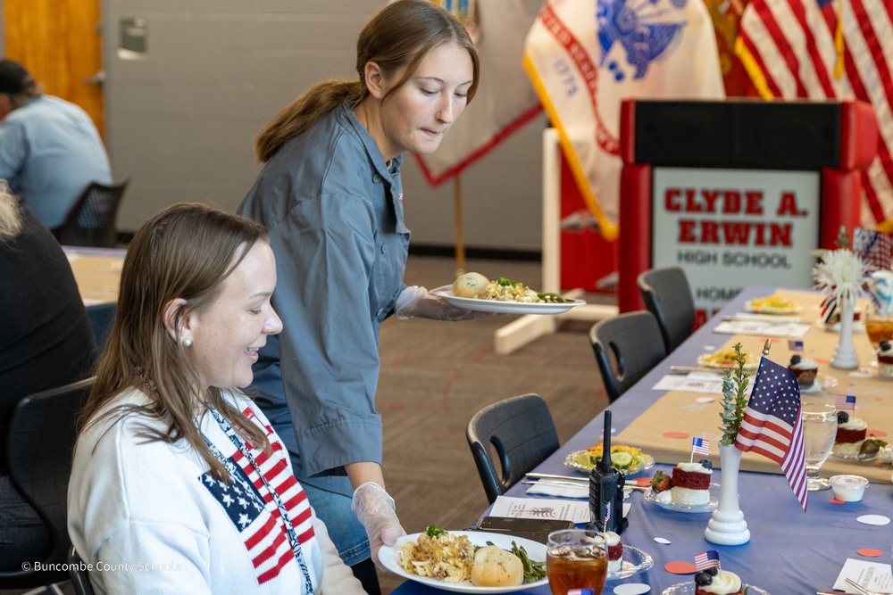 An Erwin High School FCCLA student serves a plate to a veteran
