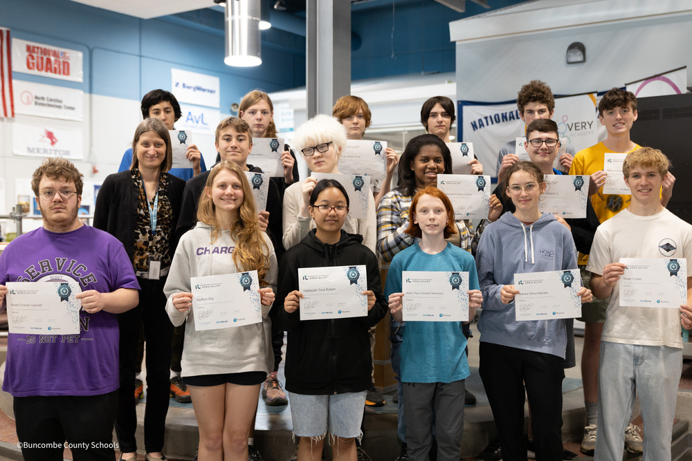 Three rows of students holding up their python coding certification
