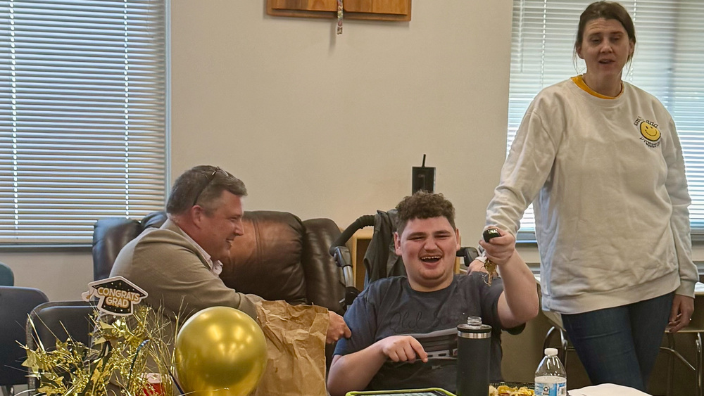 Mr. Cody smiles next to a PEP student at the table.