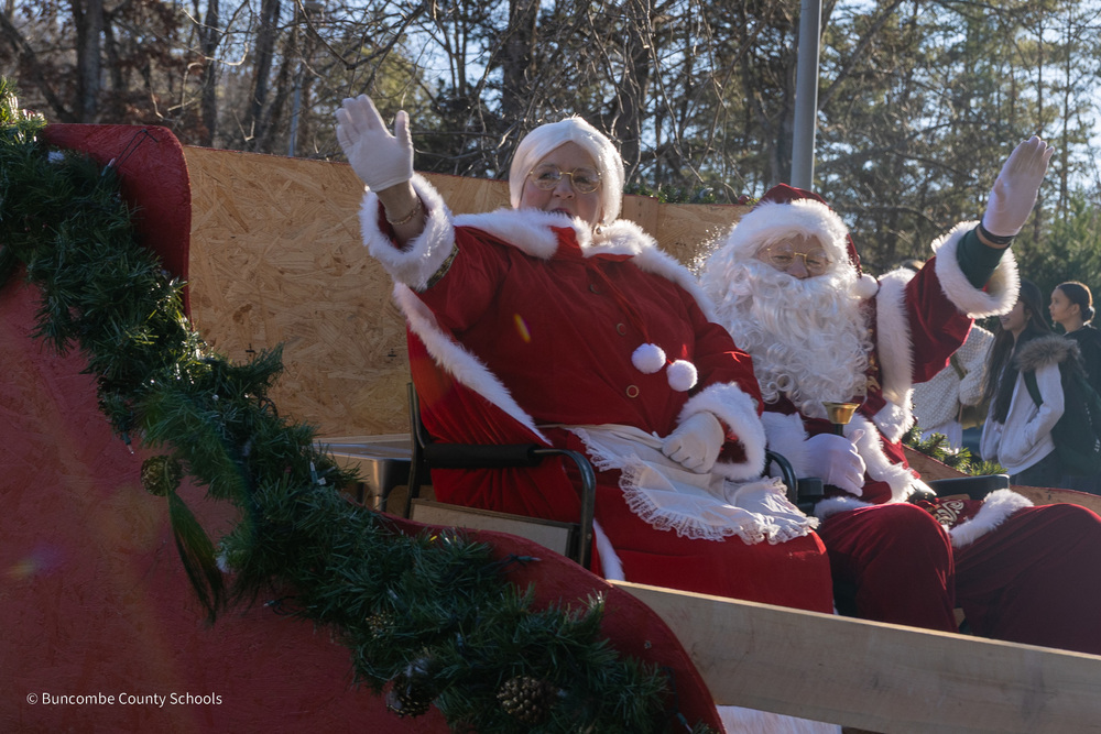 Santa and Mrs. Claus ride in their sleigh and wave along the parade route
