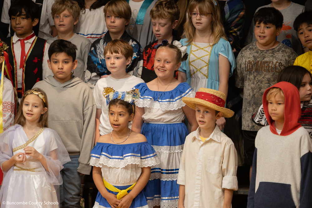 Students on stage singing a song. 